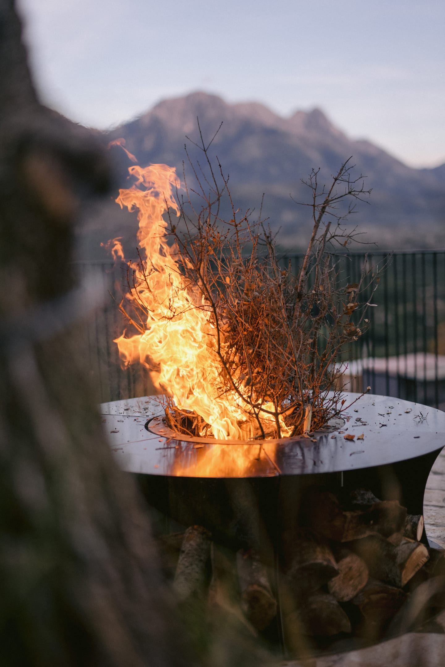Een open vuur op het terras met de bergen erachter